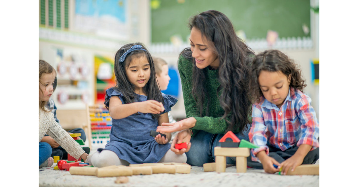 Image shows a teacher teaching kids and giving personalised attention